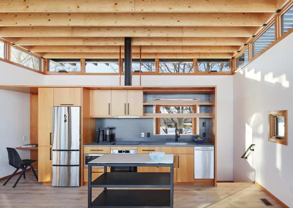 An interior of the MetalLark tower kitchen, with custom residential woodworking displayed in the cabinets and exposed ceiling beams.