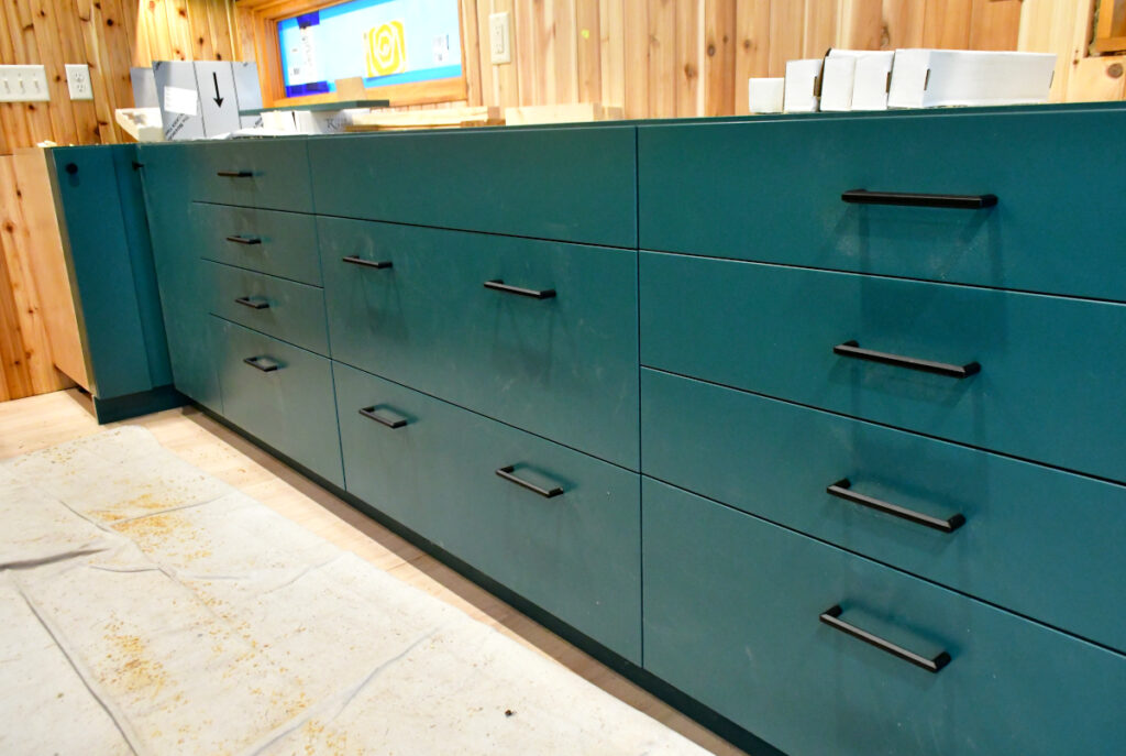 Newly installed drawer pulls on a section of kitchen cabinet drawers.